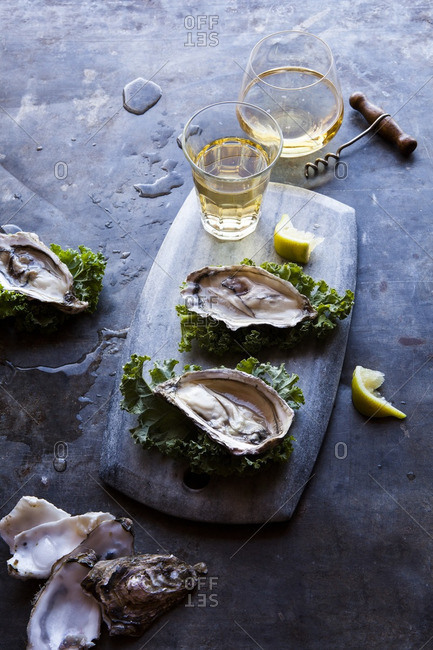 Oysters on a cutting board served with beer and champagne
