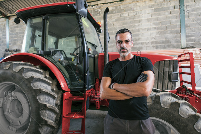 Portrait of confident mechanic at tractor