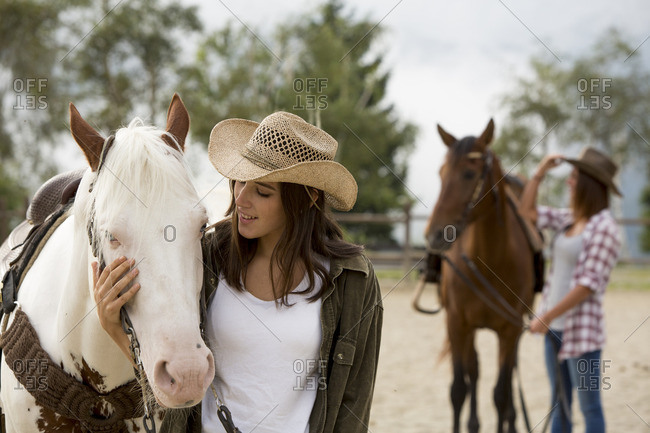 Young women with horse at riding stable