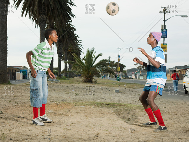 Boys playing football in street