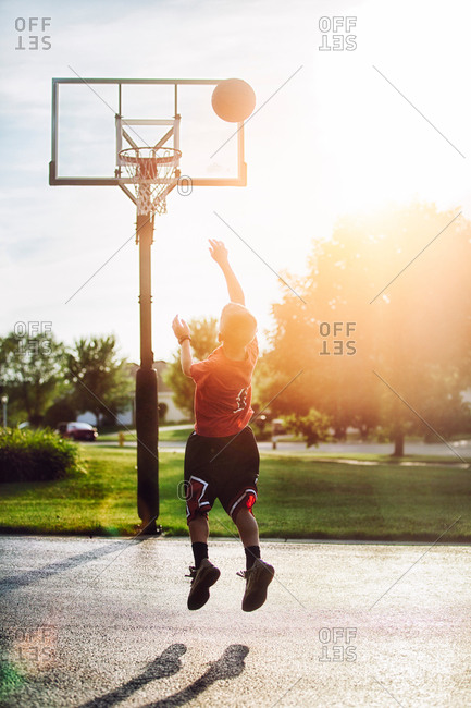 Young boy shooting basketball jump shot