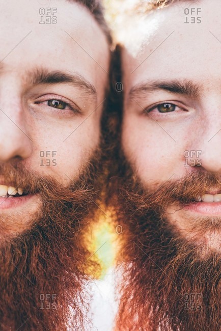 Cropped close up portrait of young male hipster twins with red beards