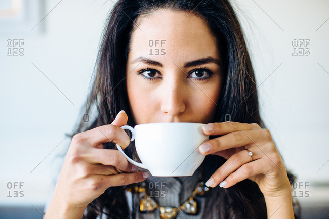 Portrait of young woman drinking coffee in boutique hotel in Italy