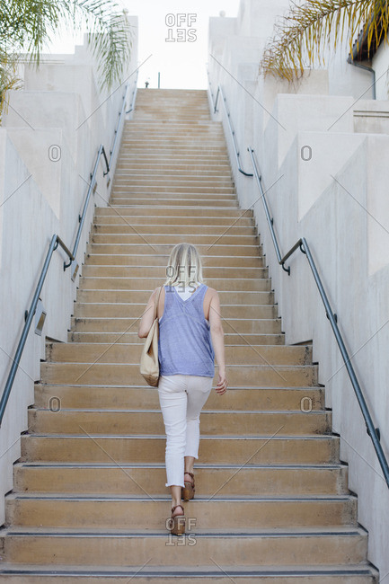 Blond woman walking up a staircase