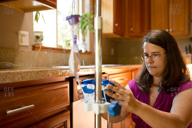 Woman setting up feeding tube pump