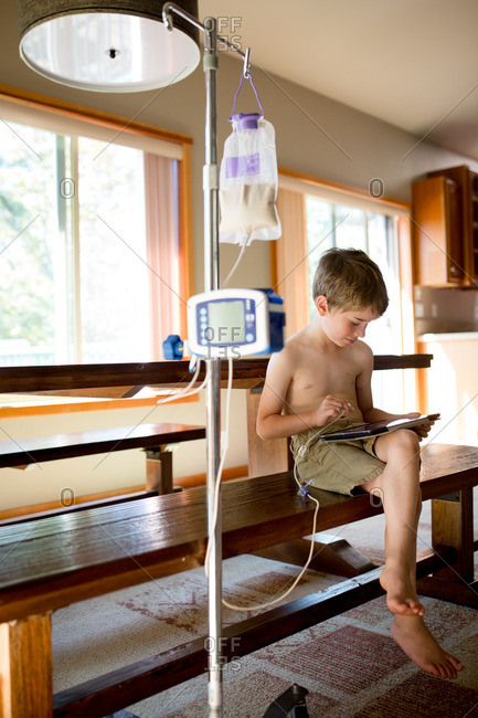 Boy with tablet using feeding tube