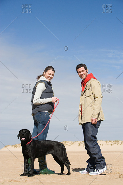 Couple with pet dog on beach