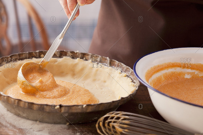 Pumpkin cake being made: pumpkin mass being spread on a short crust base