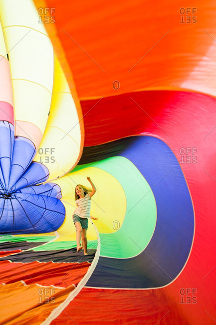 Girl playing in an inflated rainbow parachute
