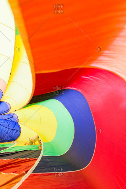 Children playing inside an inflatable rainbow parachute