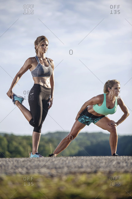 Two Women Doing Stretching Exercise On Street