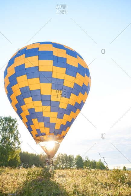 Man soaring in his hot air balloon amid the field