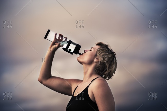 Woman replenishing with water during a workout