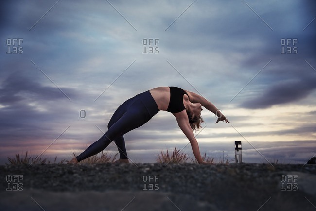 Woman practicing wild thing yoga pose outdoors
