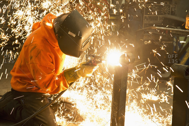 Caucasian worker welding in workshop