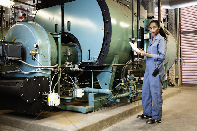 African technician standing next to machinery