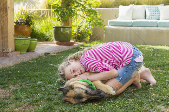Girl hugging dog in a yard