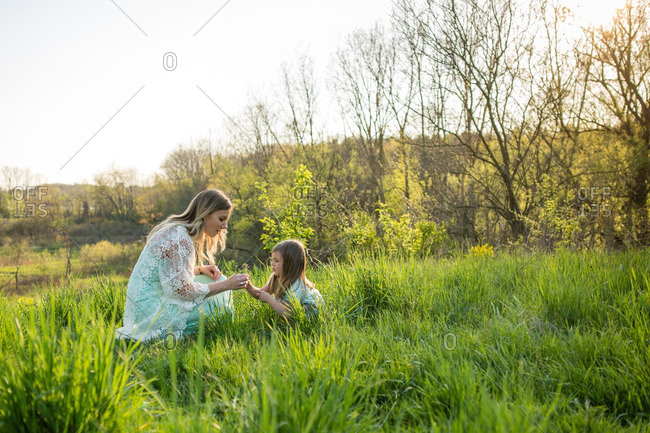 Mother and daughter picking flowers in a field