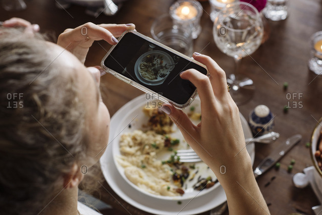 Teen girl taking picture of her plate at Thanksgiving dinner