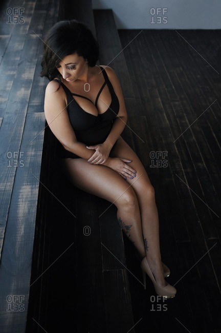 Woman wearing a bathing suit reclining against a set of wood steps