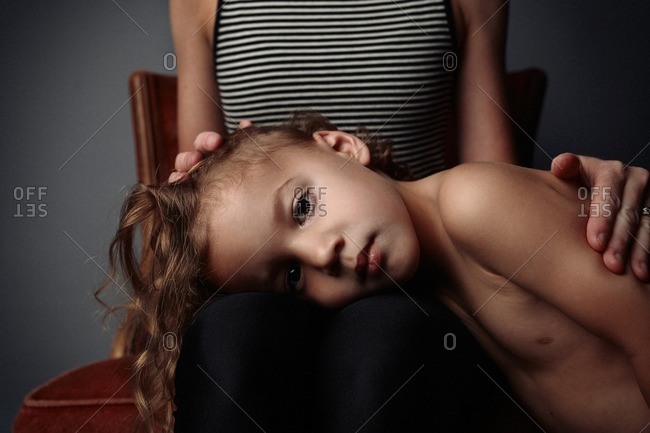 Little boy resting his head on his mother\'s lap