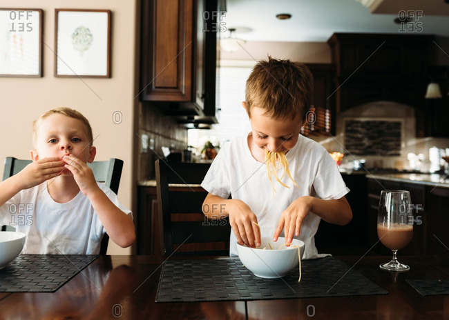 Boys eating pasta by hand