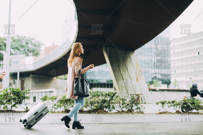 Walking woman with wheeled luggage