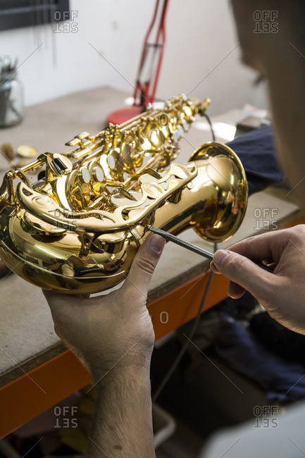 Instrument maker dismounting a saxophone during a repair