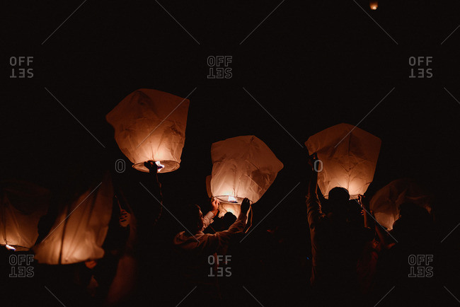 Guests sending sky lanterns into the air at a wedding reception