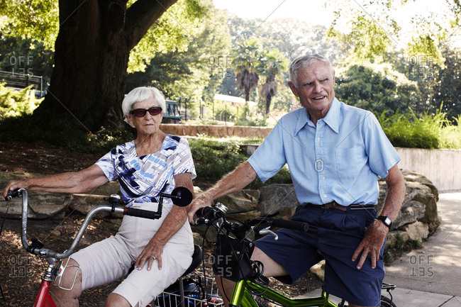 Senior cycling couple on bicycles in park