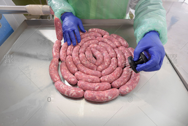 Worker making Italian sausages in sausage factory, close-up