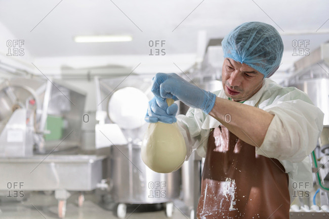 Worker hand making mozzarella ball in cheese factory