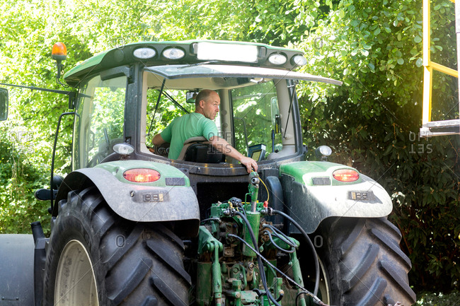Male farmer looking back to reverse tractor