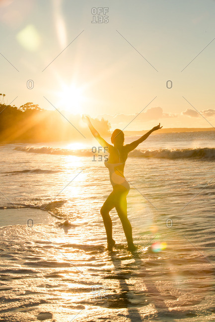 Woman at sea backlit by sunlight