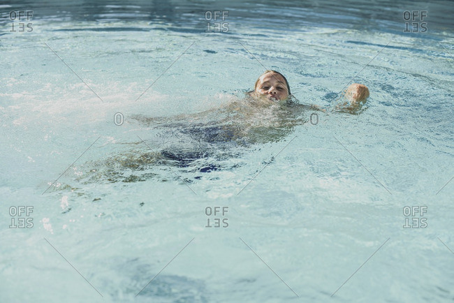 Boy splashing in a swimming pool