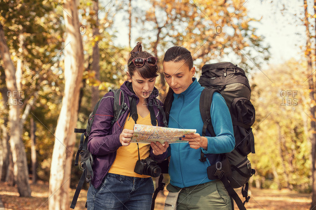 Women checking a map in fall hike