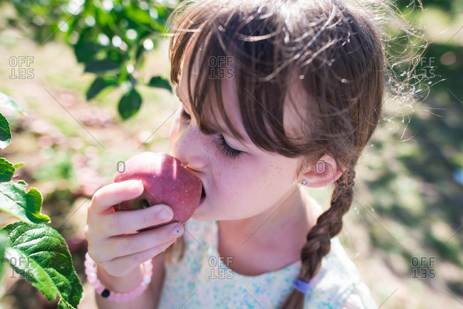 Girl biting into a freshly picked apple