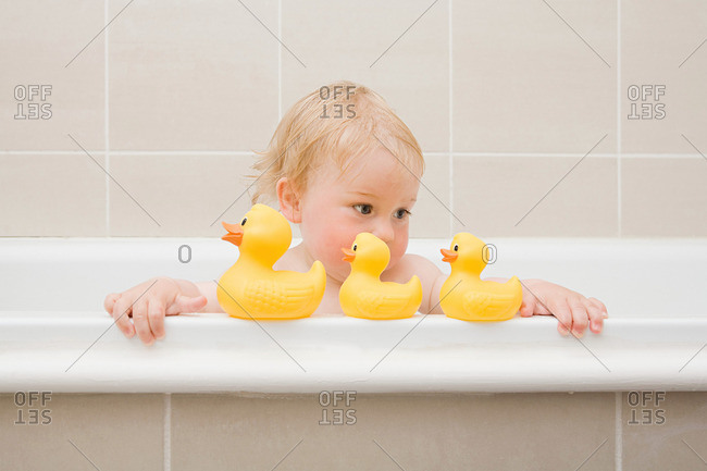 A baby boy looking at a row of rubber ducks