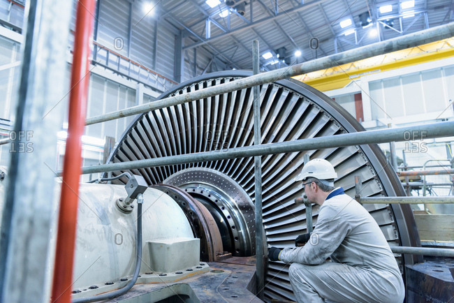 Engineer inspecting steam turbine in gas-fired power station