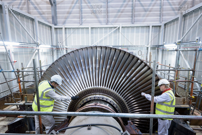 Engineers inspecting steam turbine in gas-fired power station