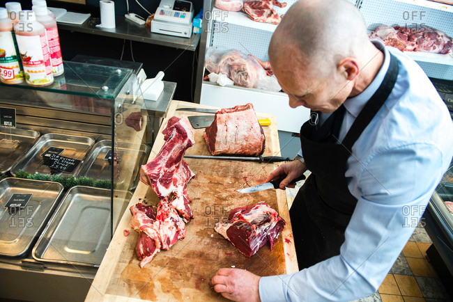 Butcher preparing meat in butcher\'s shop