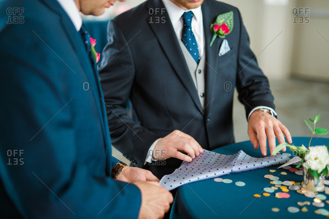 Men folding handkerchief into a pocket square