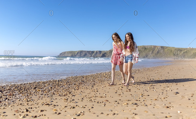 Two best friends walking along the beach