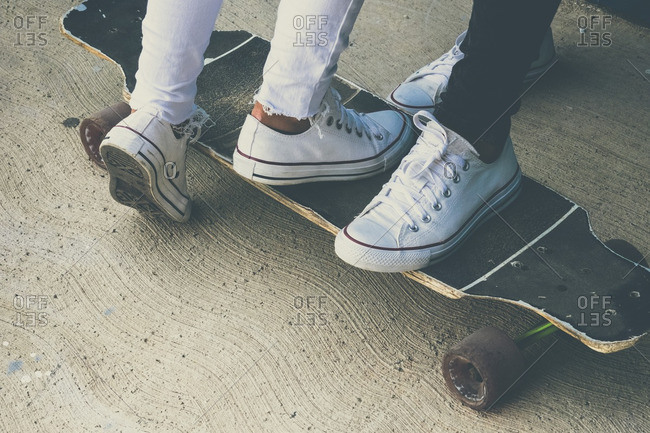 Feet of two teenagers on skateboard