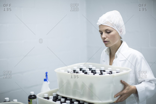 Woman carrying box of medical supplies in medical factory