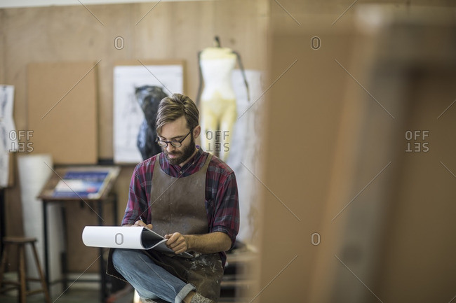 Artist in studio drawing in sketch book