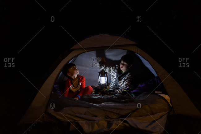 Brothers hanging out in a tent at night