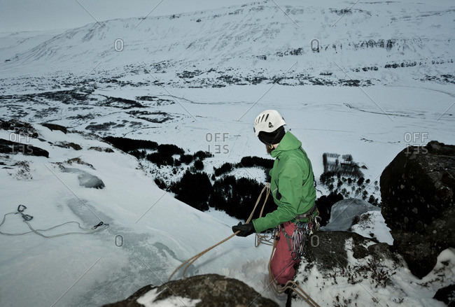 Climber with rope on snowy hill
