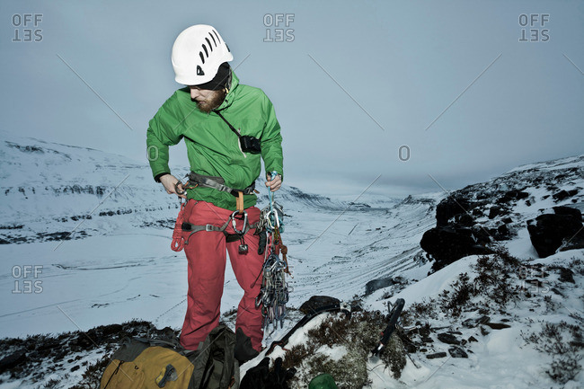 Climber with carbines on snowy hill