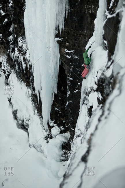 Climber with picks descending snowy hill
